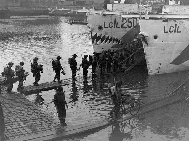Troops of the Highland Light Infantry of Canada boarding Landing Craft Infantry at dawn on June 4th.